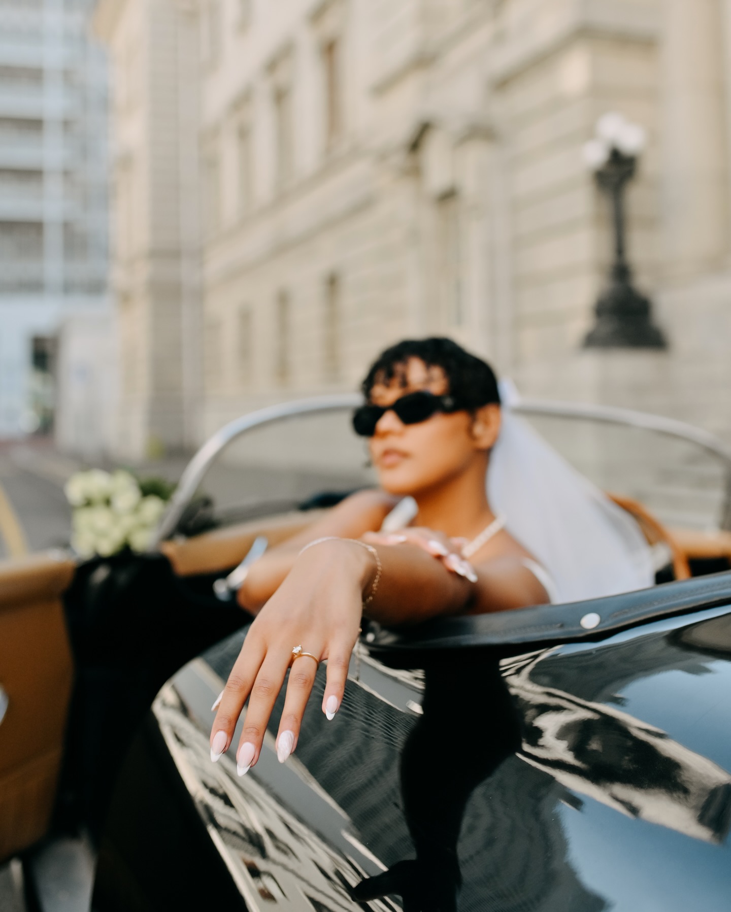 Close-up of the bride resting her hand on the Speedster door